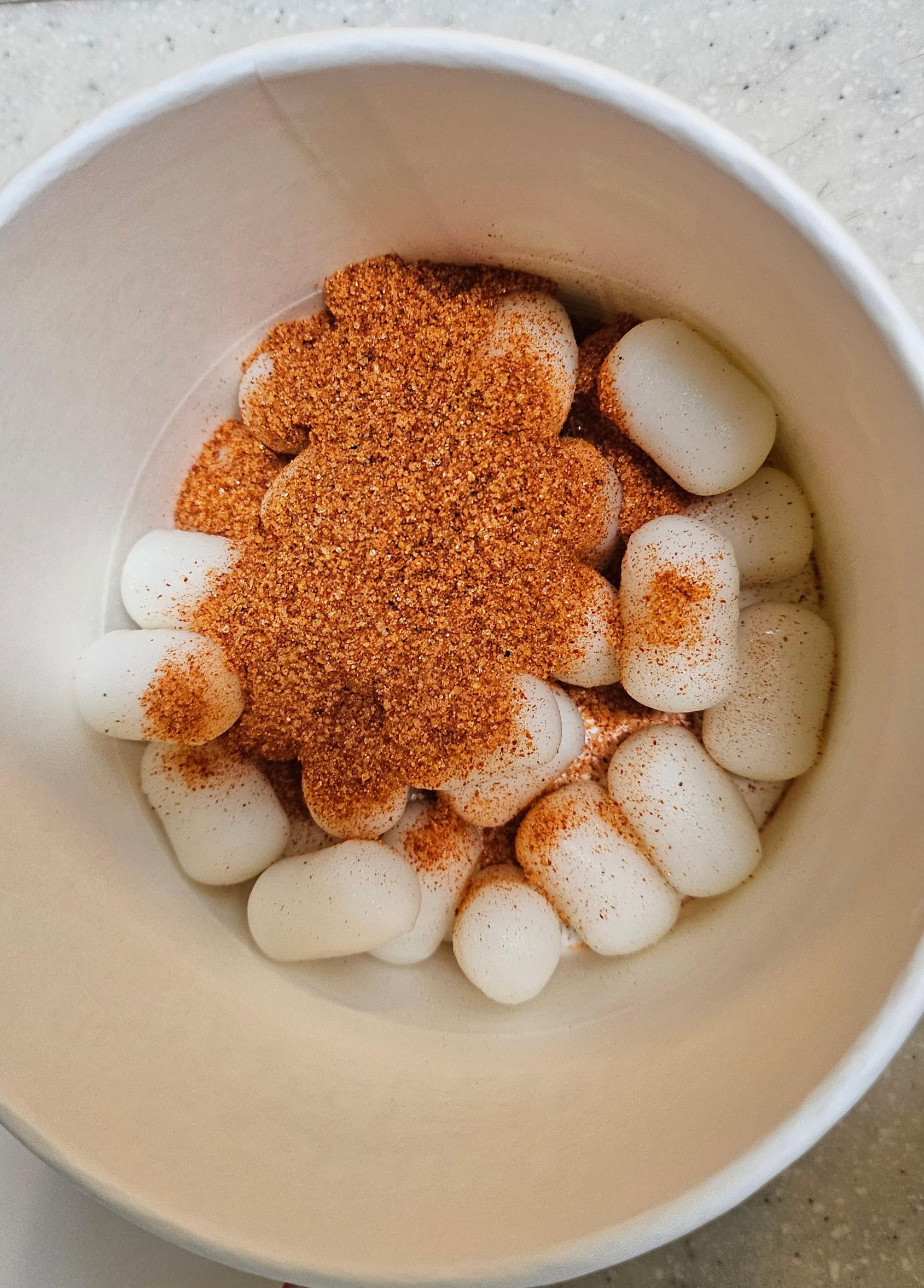 컵 안에 담긴 깨끗한 쌀떡과 분말 소스 가루의 모습.