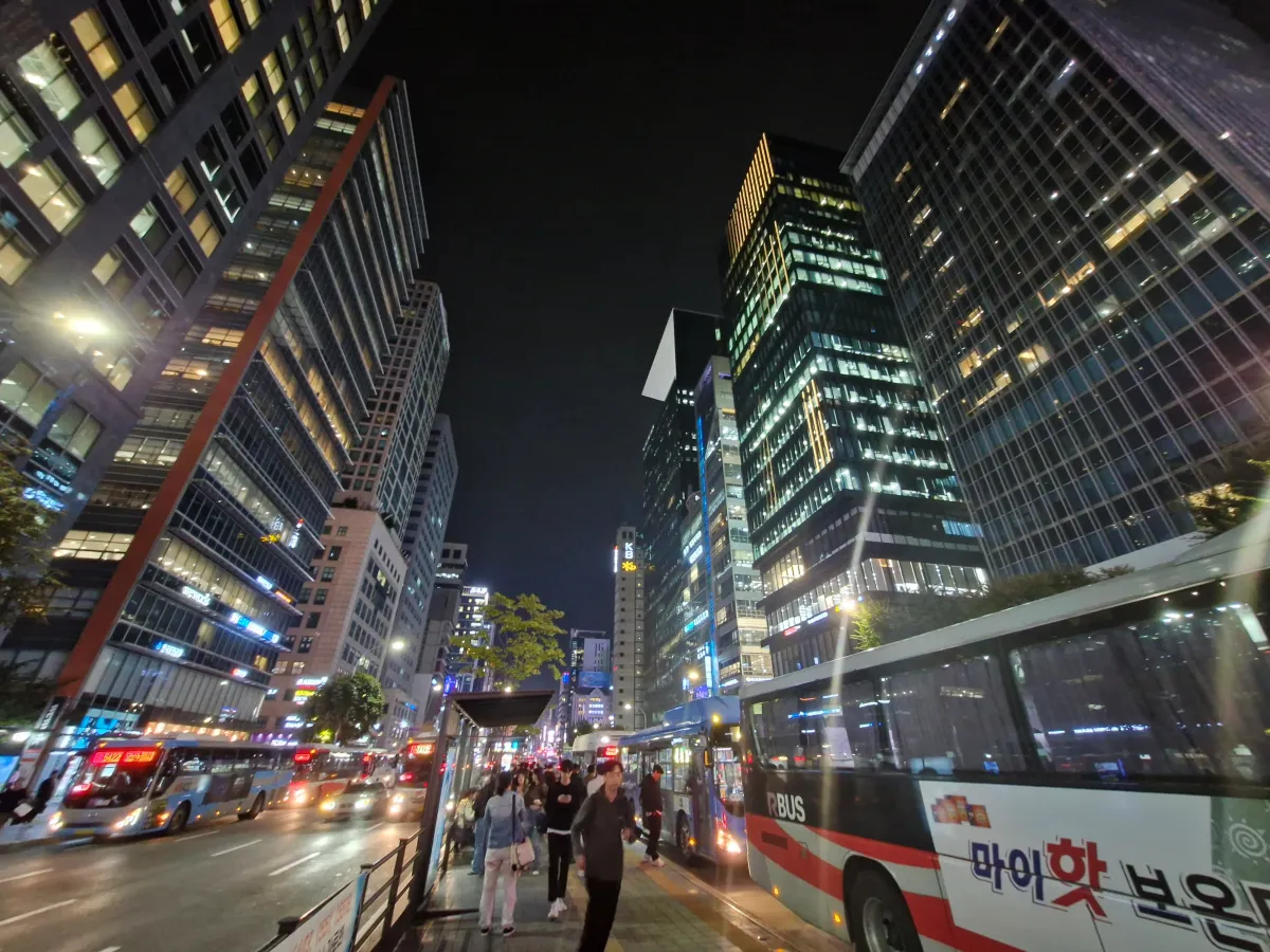 도로-한가운데에-있는-버스정류장-사이로-커다란-빌딩들이-멋있게-서있다