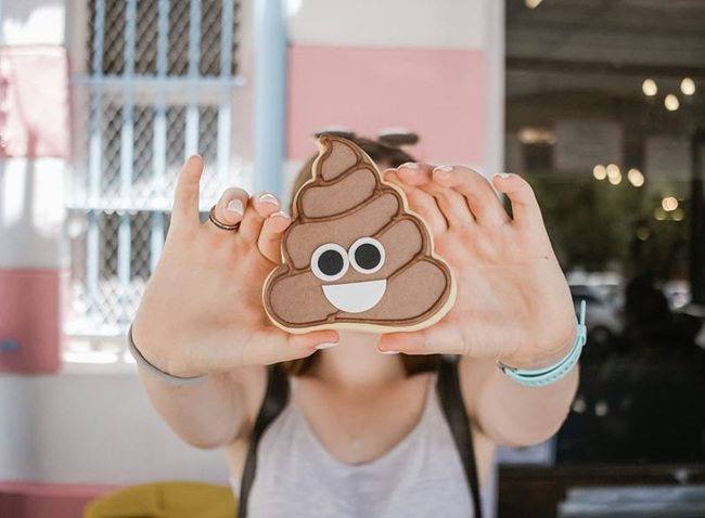 똥 모형 그림을 들고 있는 사람 사진, 출처: unsplash 제공