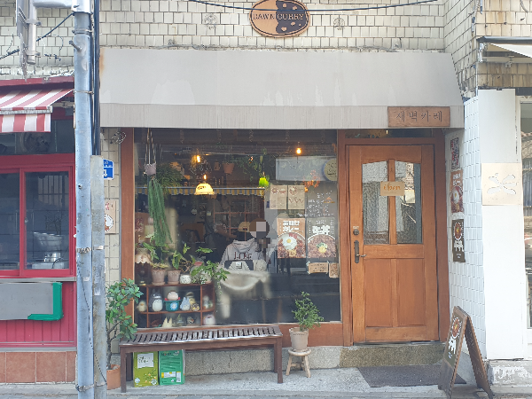 레트로한 느낌이 잘 살아있는 새벽카레. 쇼윈도우에는 화분 및 인형들이 놓여 있다.