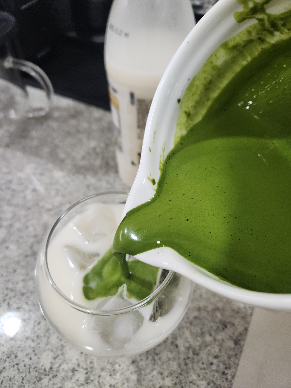 말차를 얼음과 막걸리가 담긴 컵에 붓는 모습