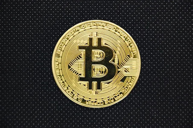 검은 바탕 위에 놓인 금색 비트코인 동전&amp;#44; 가상화폐 투자와 디지털 자산의 상징