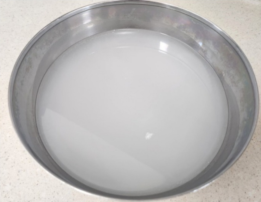 야생에서 채취를 한 쌀을 물과 함께 믹서로 갈은 후에 물만 따로 모아서 동그란 쇠그릇에 반쯤 담아 둔 것을 바닥에 놓아두고 찍은 사진