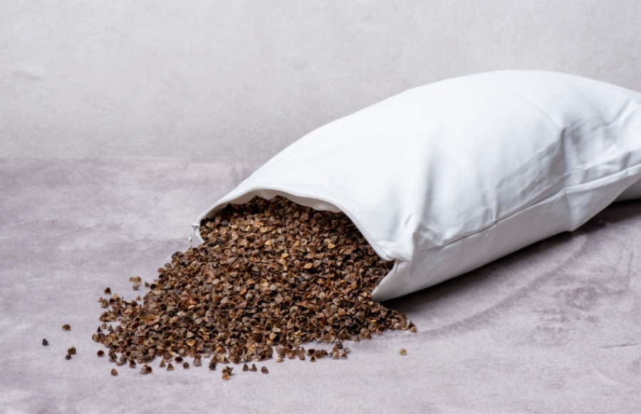 야생에서 채취를 한 메밀을 껍질을 까서 모아둔 것을 흰색 베개포에 가득 담아둔 것을 쓰러뜨려 하얀 바닥 위에 쏟아지게 놓아두고 찍은 사진