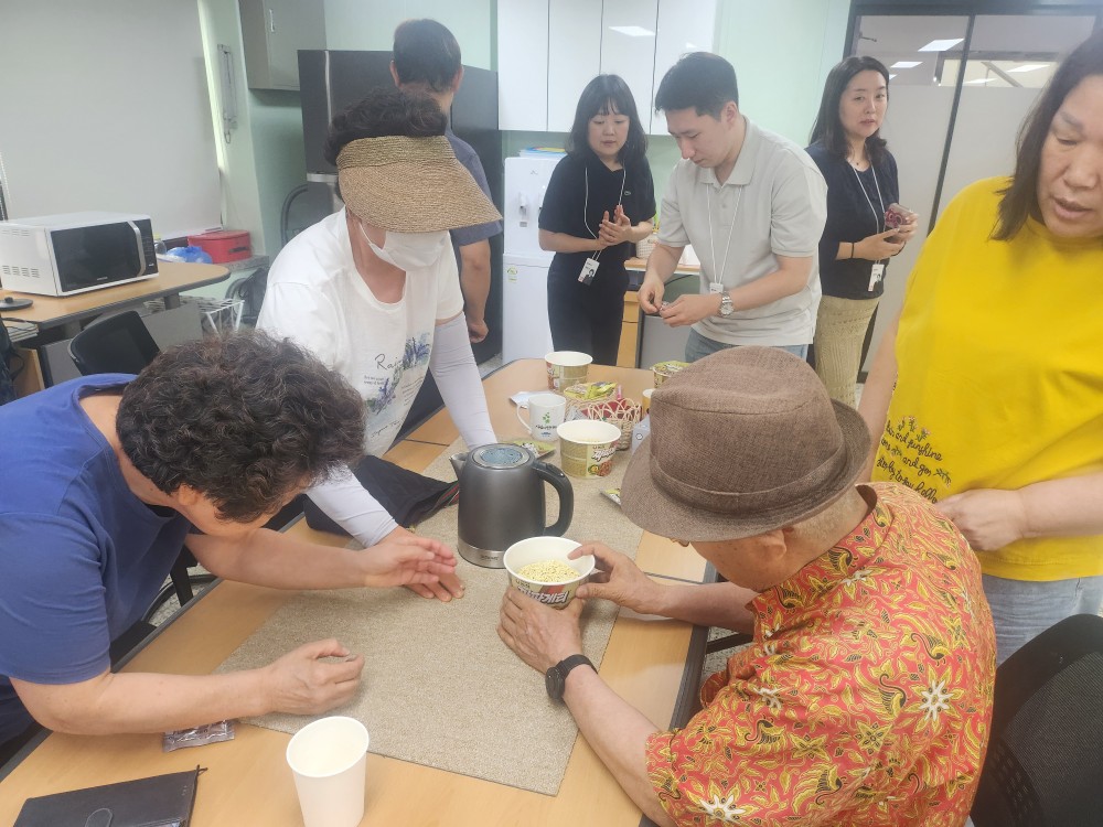 이미지설명: 시각장애인쉼터 이용인이 컵라면 용기 안쪽을 만져보고 있다.