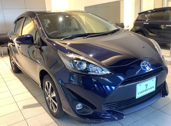 진한 파란색의 자동차가 조명 밑에 세워져 있다.