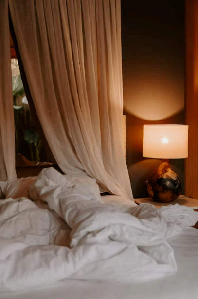 전구색 스탠드 조명과 커튼이 드리운 침실&mdash;저녁 클린업 루틴의 포근한 수면 환경