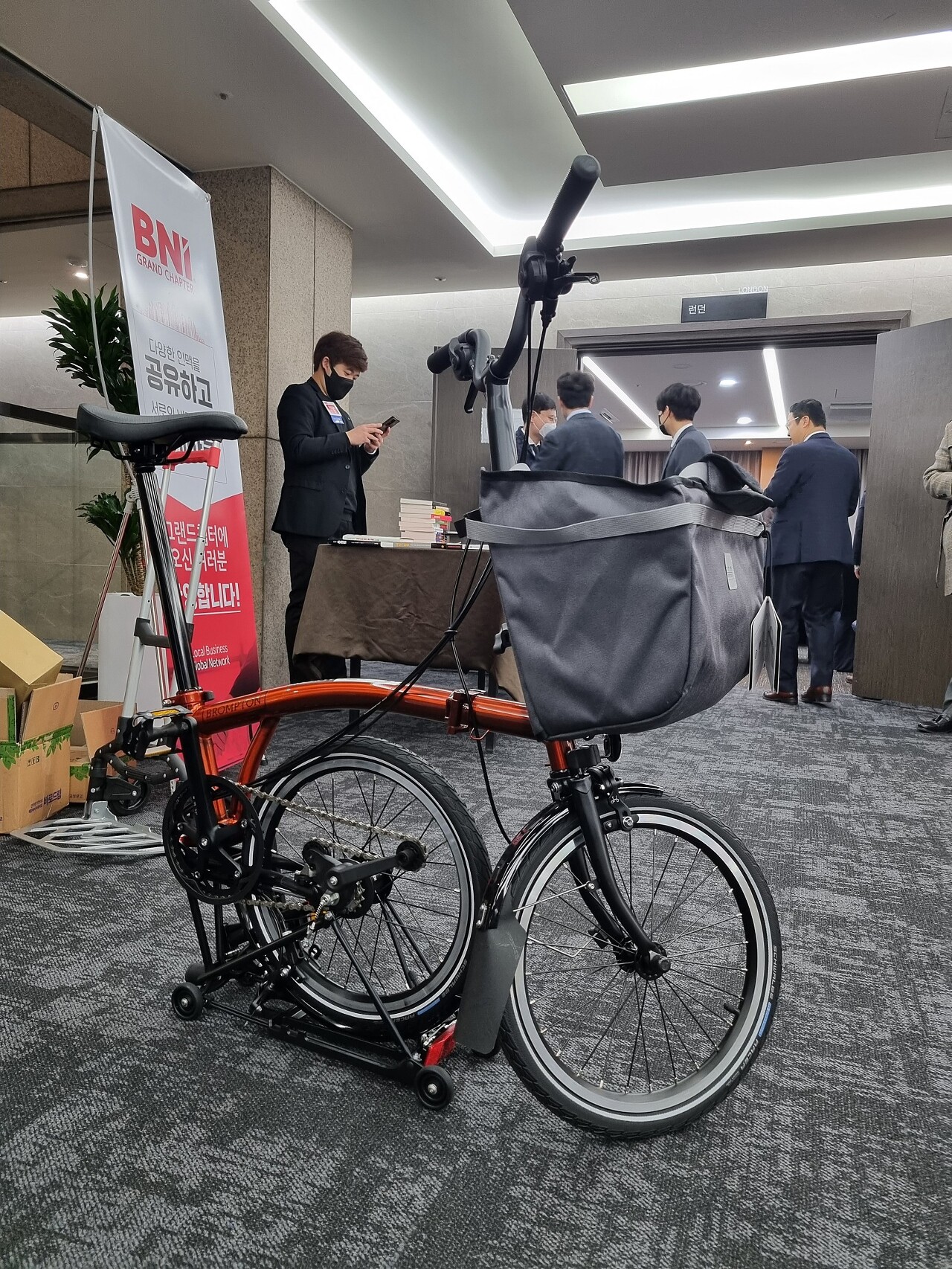 허슬린바이크 서현웅대표의 출시된 브롬톤 바버 에디션 접이식 자전거가 로비에 반 쯤 접혀서 있습니다.