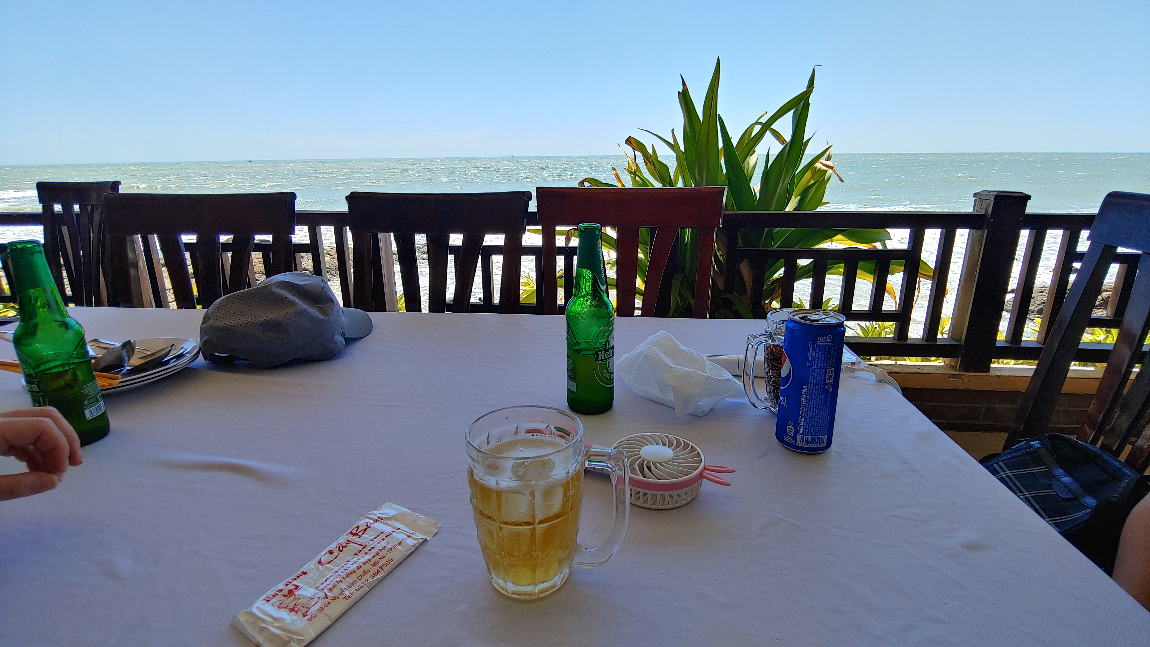 바다 앞 테이블에서 맥주 한잔하는 모습
