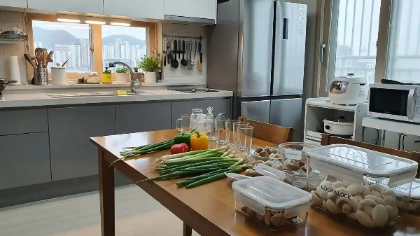 식탁 위, 냉장고에 넣을 채소를 나눠 담기 위한 유리 용기가 놓여져 있음