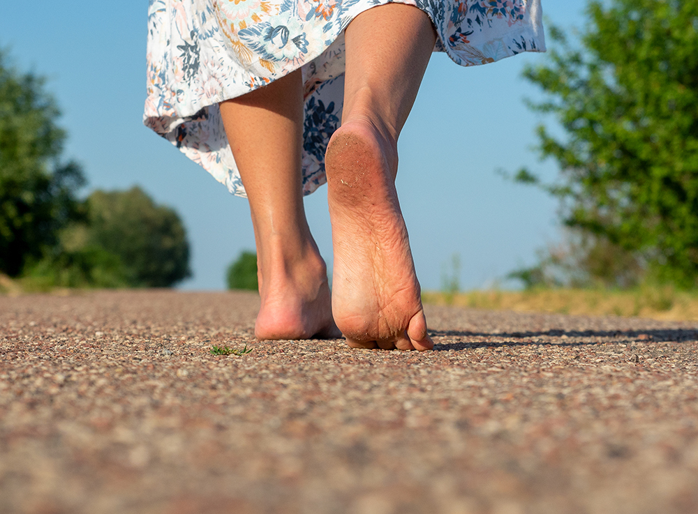 흙바닥을 맨발로 걷고 있는 여성의 발바닥 사진