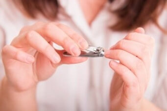 흰-브라우스를-입은-여성이-손톱을-깍는-모습