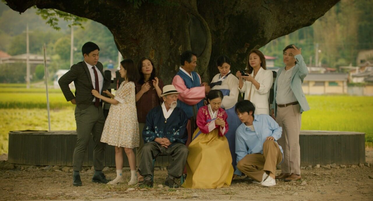 제삿날 가족들이 모두 모여 나무 아래에서 가족사진을 찍고 있는 모습