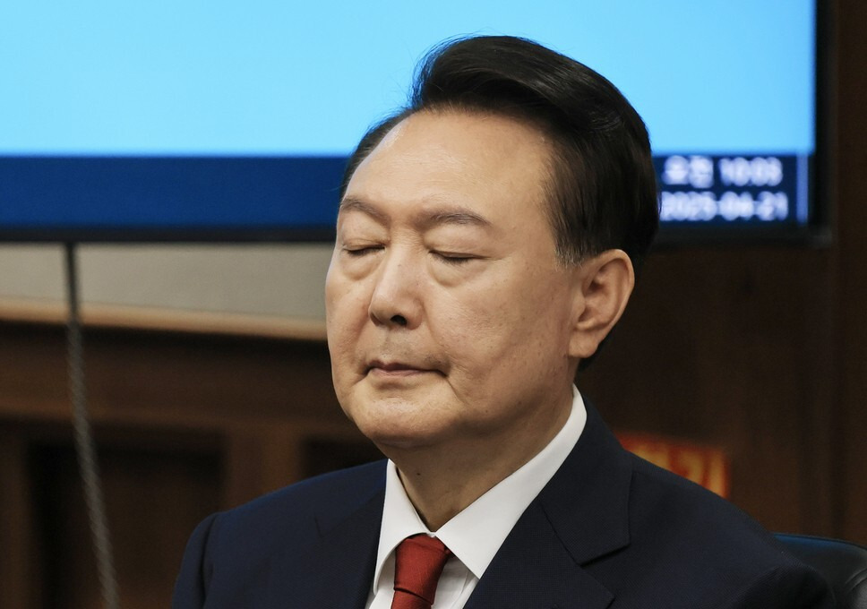 윤석열 전 대통령이 21일 오전 서울 서초구 서울중앙지법에서 열린 내란 우두머리 혐의에 대한 2번째 정식 재판에 출석해 눈을 감은 채 피고인석에 앉아 있다. 사진공동취재단