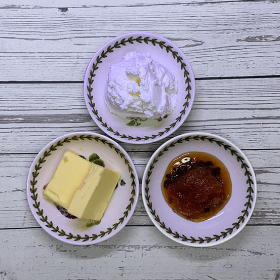 소스용 접시 세 개에 각각 그릭 요거트, 꿀, 버터 두 덩이가 담겨 있다