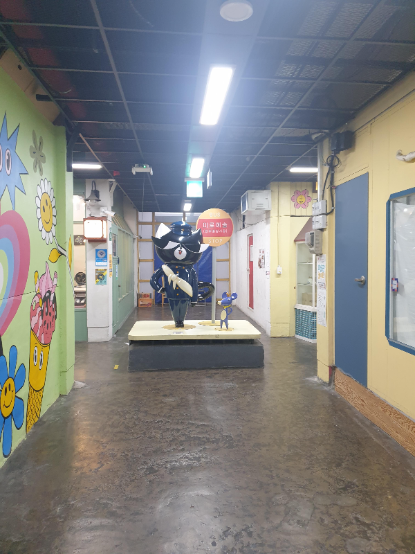 벽에는 벽화가 있고 중앙에는 조형물이 있는 골목