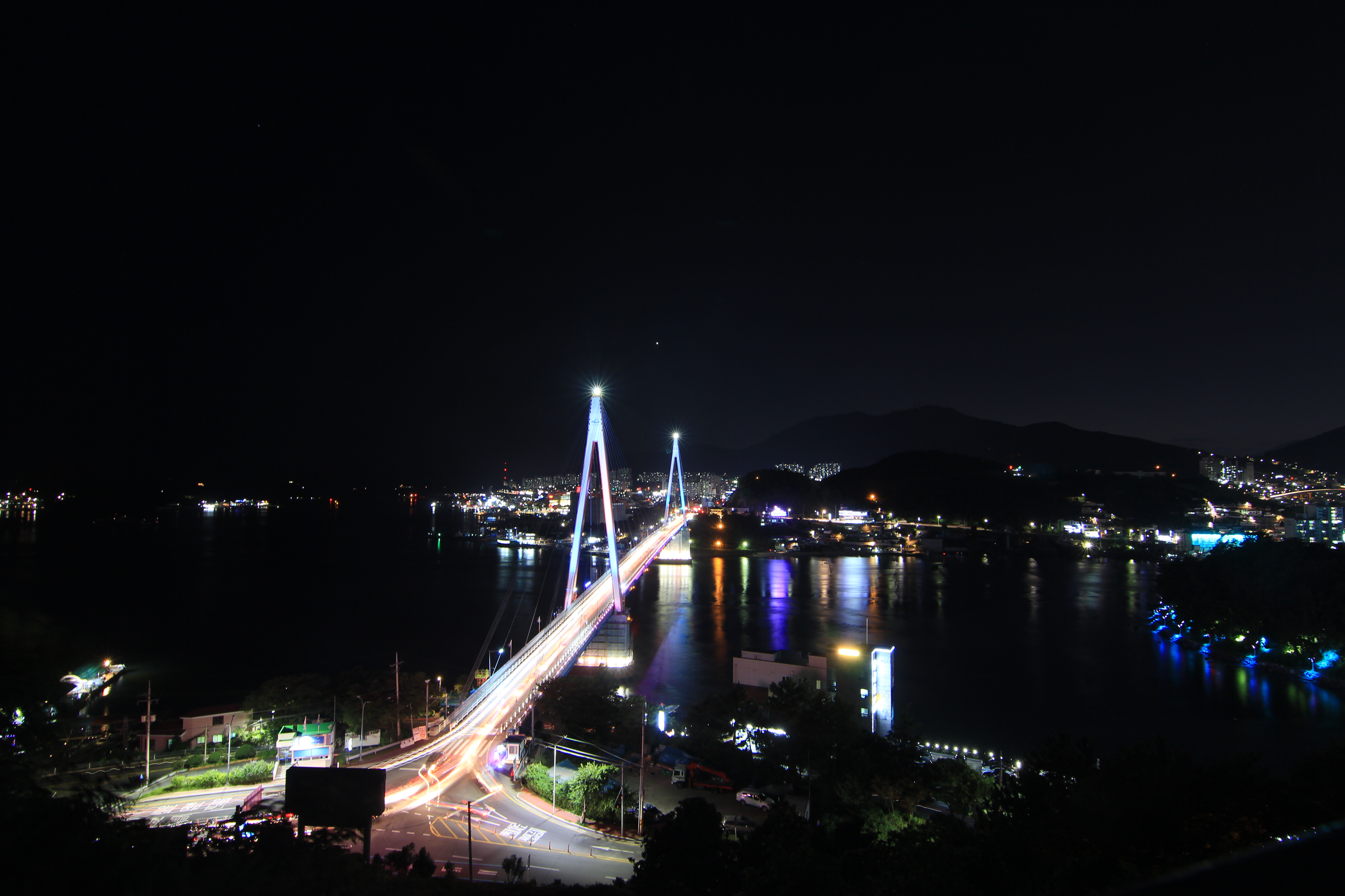 전라남도 여수 돌산대교의 야경 전경 — 푸른빛 조명 아래 반짝이는 교량과 여수 앞바다의 불빛이 어우러져 로맨틱한 가을밤 분위기를 자아내는 풍경 이미지