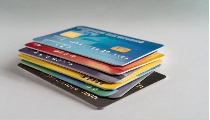 다양한 신용카드가 쌓여 있는 모습으로 소비쿠폰을 다수 보유하거나 차명 거래 시도와 관련된 부정행위를 연상시킵니다