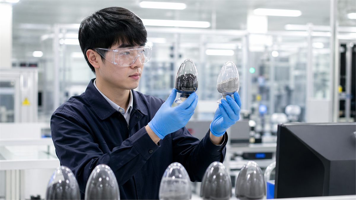 기술자가 배터리 소재 샘플을 검사하는 생산 현장 모습 