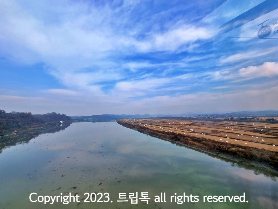 푸른하늘 아래 쭉뻗어있는 임진강이보이고 왼쪽엔 흙색의 밭이보인다.