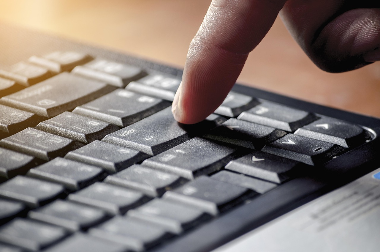 손가락으로 키보드 엔터 키를 누르는 장면