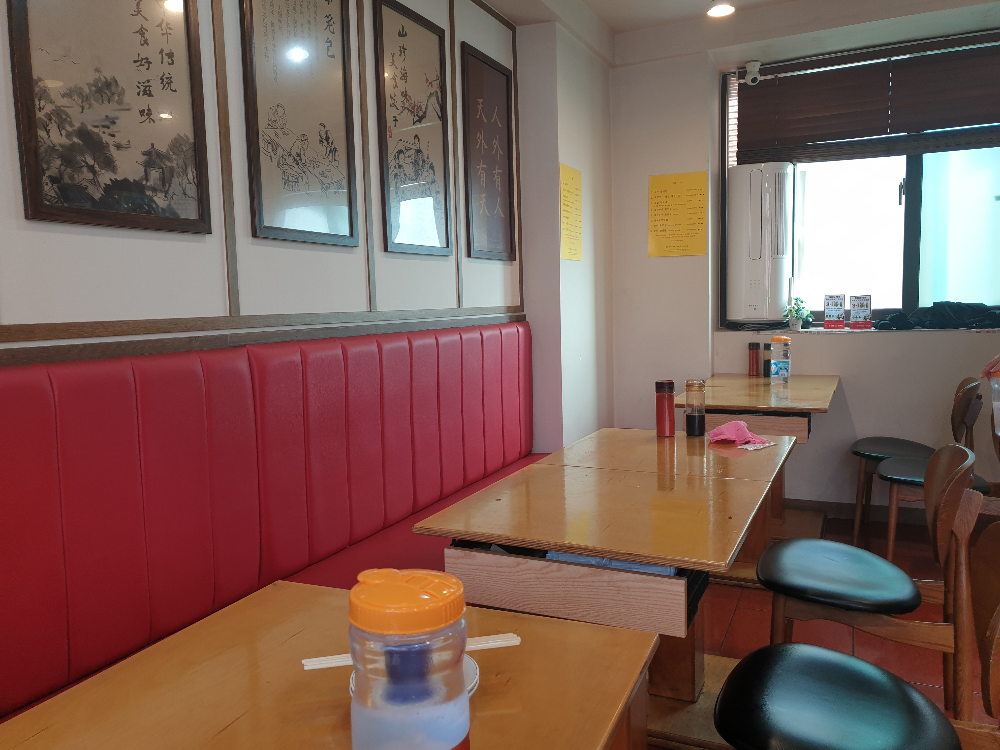 붉은 의자와 우드 상판 테이블 벽면에는 먹으로 그린 액자가 걸려있다ㅣ.