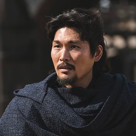 어느 실외를 배경으로 남색 망토를 두르고 수염이 난 아라문의 검 대사이 캐릭터