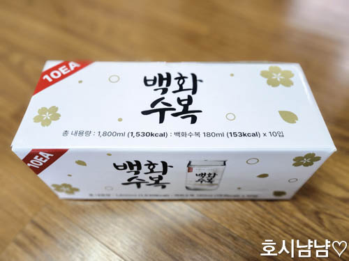 백화수복 원컵 10개입 패키지가 테이블 위에 놓여 있는 모습. 180ml 소용량 청주 세트 박스 디자인과 제품 정보를 보여주는 근접 사진