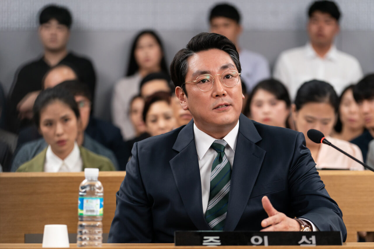 소년들의 사건을 담당했던 오 검사가 증인석에 앉아 심문을 받는 모습