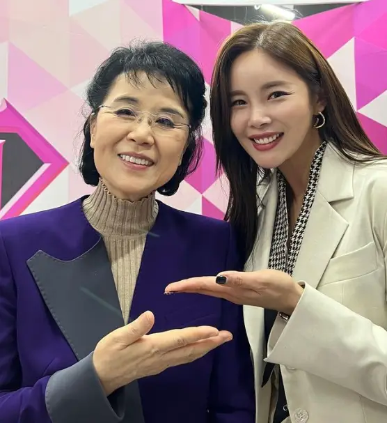 현역가왕- 보라색 쟈켓을 입고 아이보리색 폴라를 입은 심수봉과 옆에서 아이보리색 쟈켓을 입고 긴머리를 풀어헤친채 미소짓는 조정민