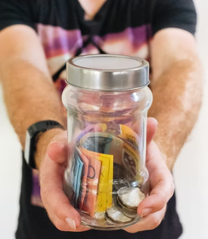 남자가 유리병에 든 돈을 건네주는 장면