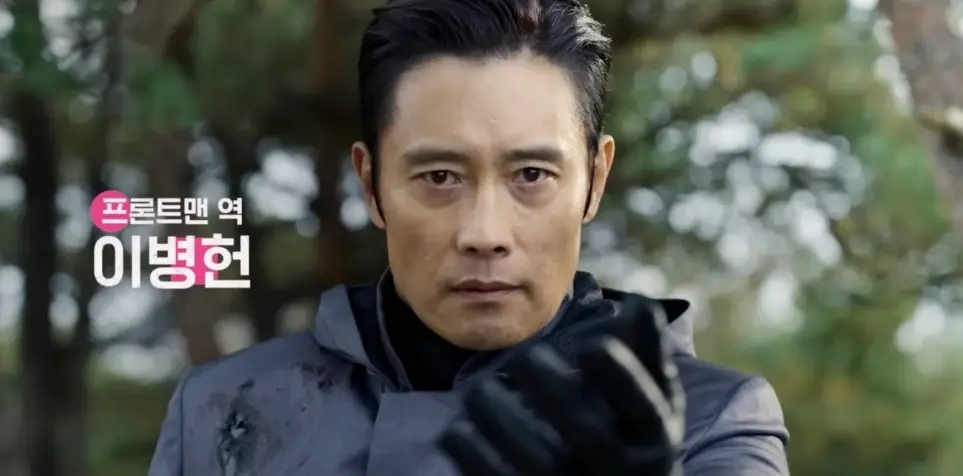 오징어게임2-
보라색 배경 검은색 머리 이병헌이 비장한 얼굴로 손을 내미는 모습