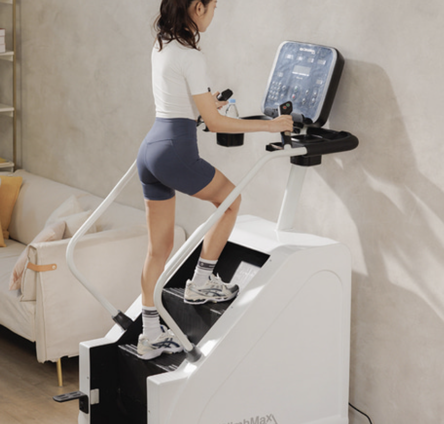 여성이 스텝밀 운동기구로 운동을 하고 있다