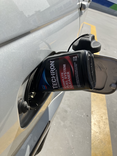 자동차 주유구에 쉐브론 테크론 연료 첨가제를 주입하는 장면 &ndash; 연료 첨가제 사용 방법 예시