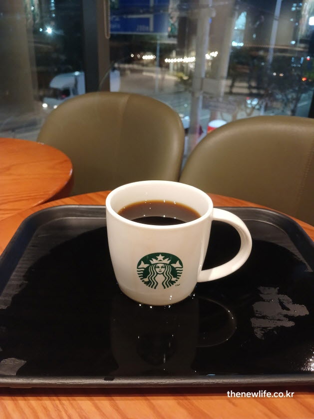 카페 실내에서 따뜻한 블랙커피 한 잔을 담은 스타벅스 머그컵