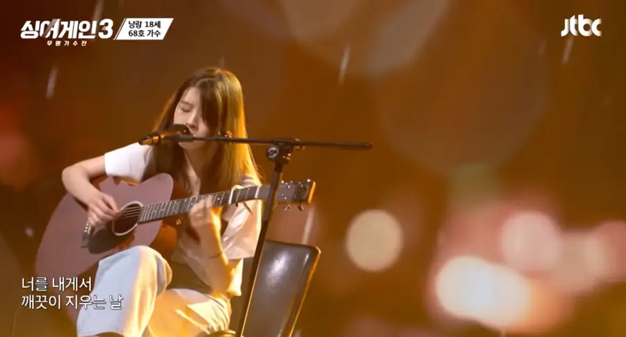 싱어게인3-
흰색반팔티에 회색바지를 입고 긴생머리를 늘어뜨린채 갈색기타를 치며 스탠딩마이크에 입을대고 노래하는 68호