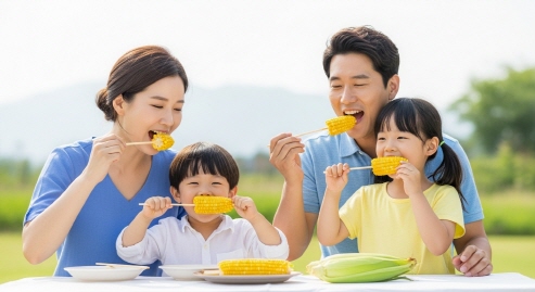 여름철 초당옥수수를 시원하게 즐기며 환하게 웃는 한국인 가족