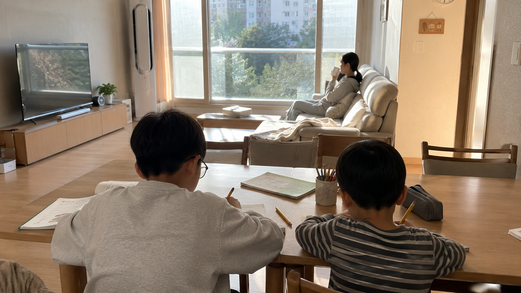 초등학생 형제가 식탁에서 숙제를 하는 모습