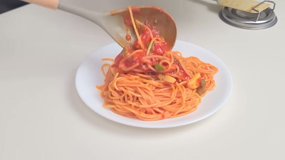 완성된 토마토 파스타를 접시에 담는 모습