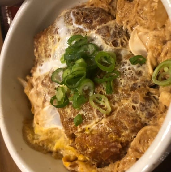 접시안에 계란반죽이 된 무언가가 담겨 있고 위에 썰린 파가 올라가 있다.