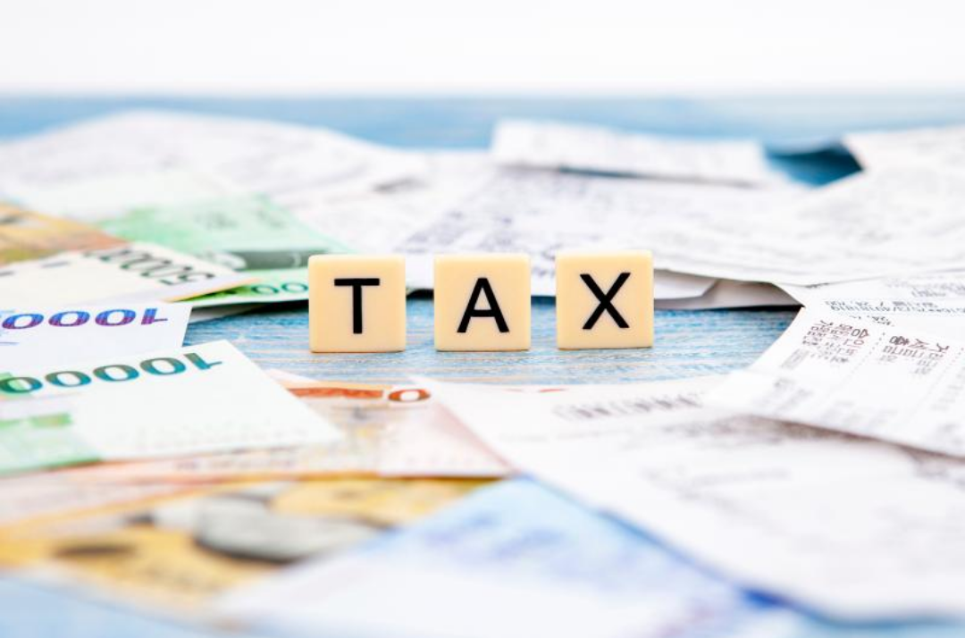 현금과 영수증이 잔뜩 널려있고 가운데 tax라고 써있다.