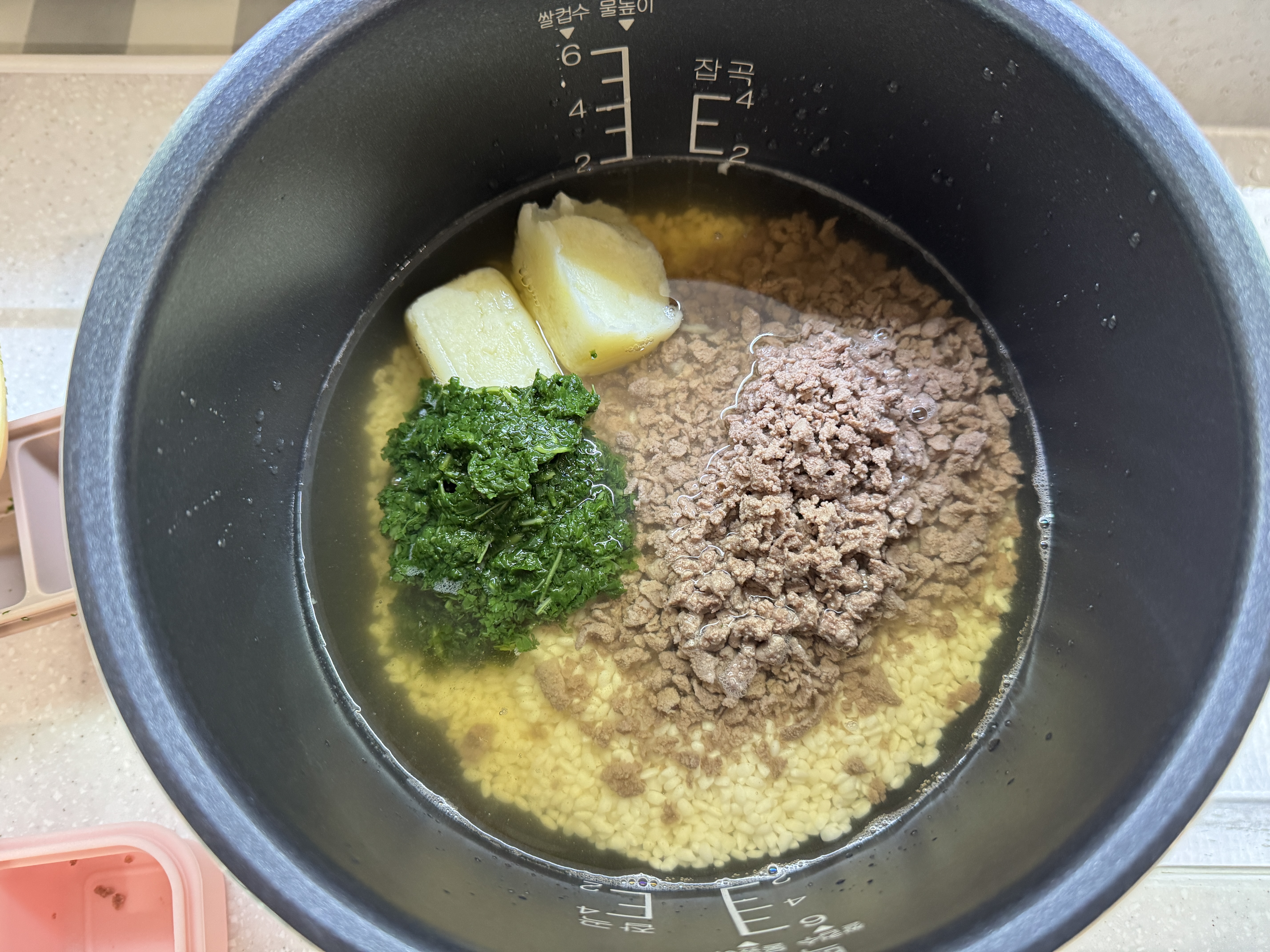 밥솥에 불린 쌀과 채수, 소고기, 감자, 아욱을 넣은 사진