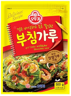 나무 도마 위에 밀가루 반죽이 놓여 있고, 밀대가 옆에 있습니다.