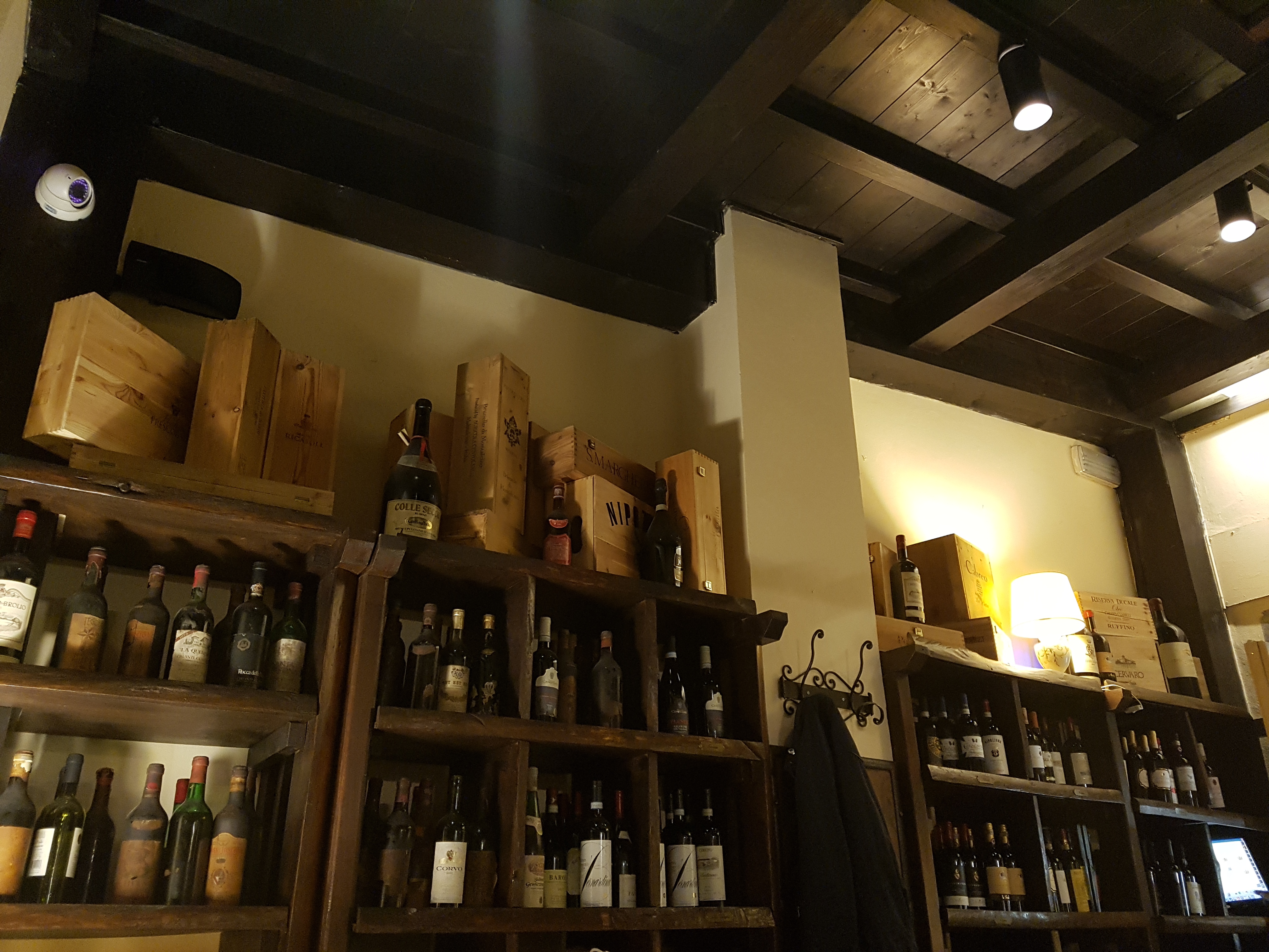 Le Fonticine 레스토랑 내부의 고풍스러운 와인 진열장과 나무 천장 인테리어