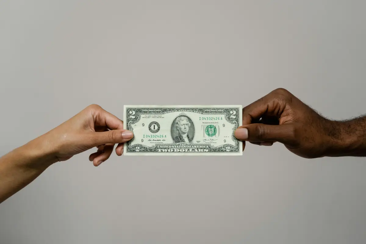 2명의-사람이-1달러를-주고-받는-사진