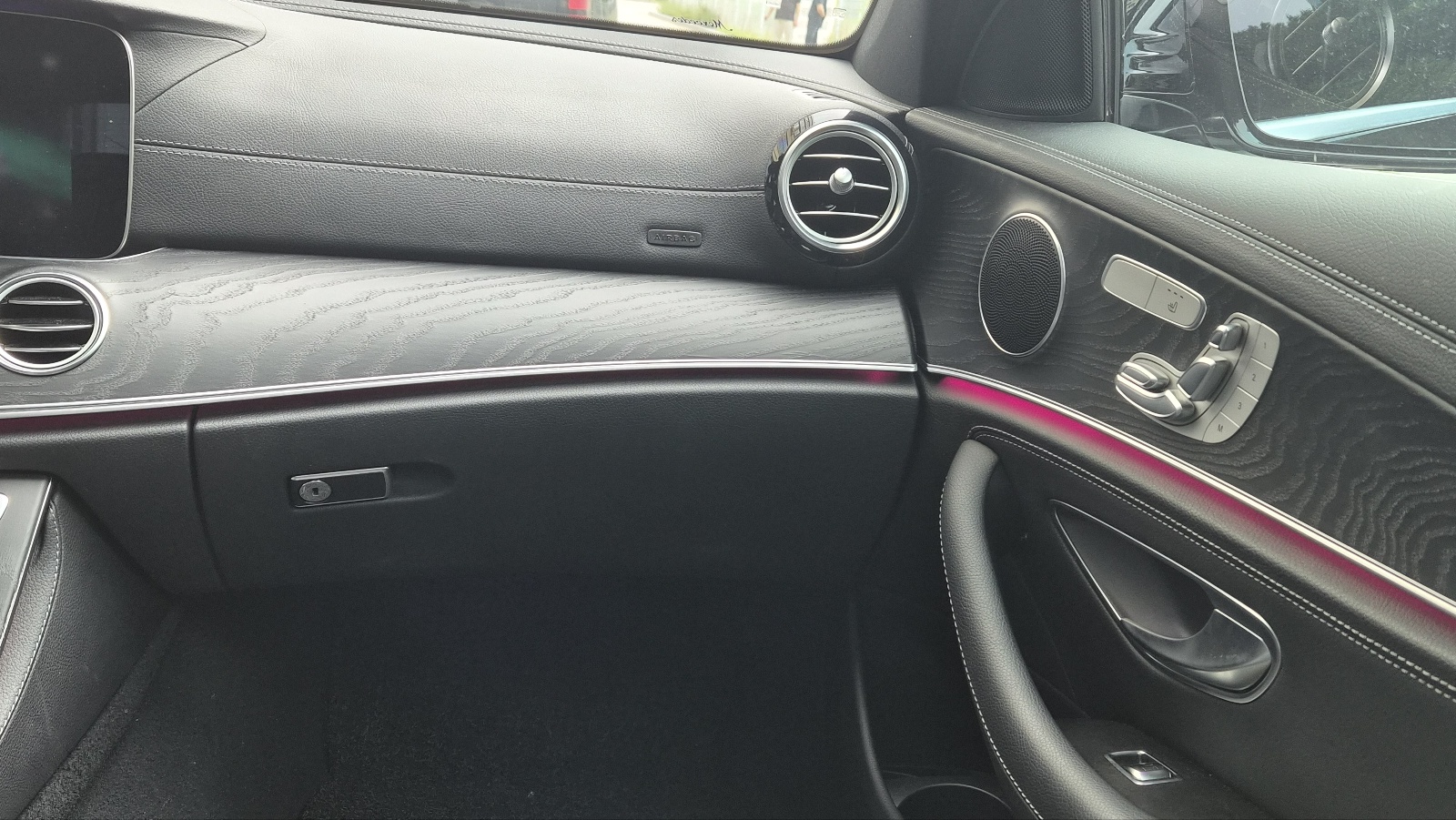 벤츠 E클래스 조수석 글로브박스 외부, 대시보드와 송풍구, 앰비언트 라이트가 보이는 실내 모습