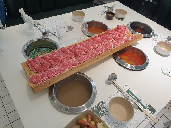 다섯 개의 화구에 네 개 솥이 세팅 된 모습. 각 화구에는 각기 다른 육수가 담겨있다. 그 위에 주문한 고기