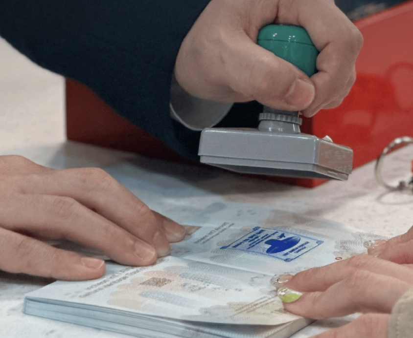 여권 위에 스탬프를 찍는 모습