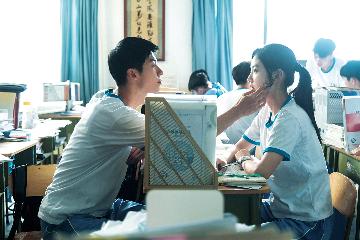 영화 여름날 우리 스틸컷, 교실에서 두 주인공이 마주 앉아 눈빛을 나누며 첫사랑의 설렘을 전하는 장면