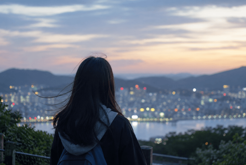 초저녁 도시 불빛을 보며 생각하는 여학생
